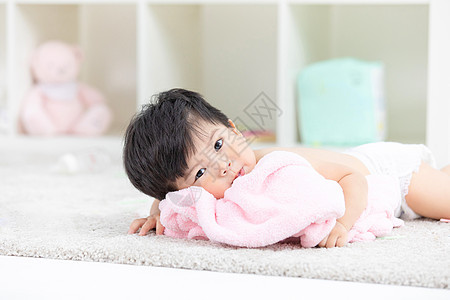 可爱宝宝裹着浴巾在地毯嬉戏图片