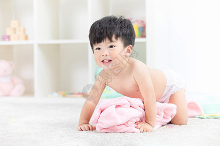 可爱宝宝裹着浴巾在地毯嬉戏图片