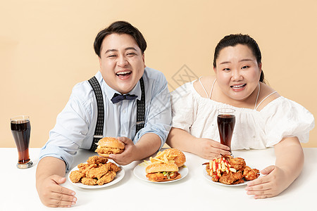年轻肥胖男女大口吃快餐图片
