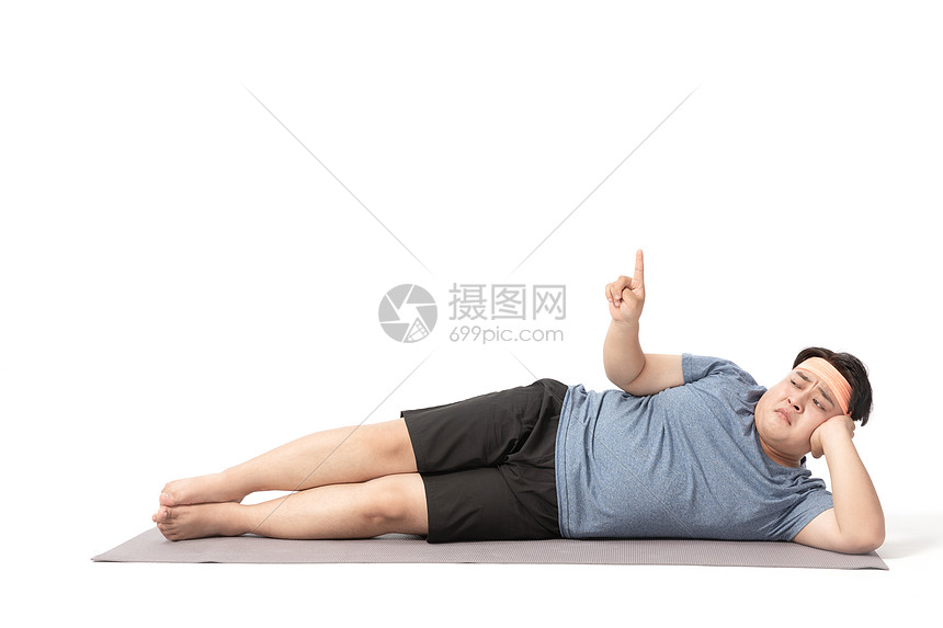肥胖男士躺在瑜伽垫手指上面图片