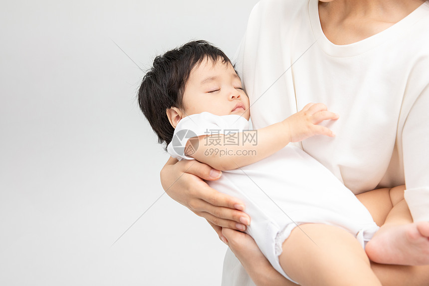 年轻妈妈抱着熟睡的宝宝图片