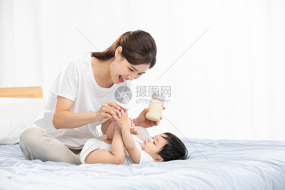 年轻妈妈用奶瓶辅助宝宝喝奶图片