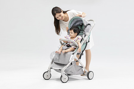 年轻妈妈用婴儿车带娃背景图片