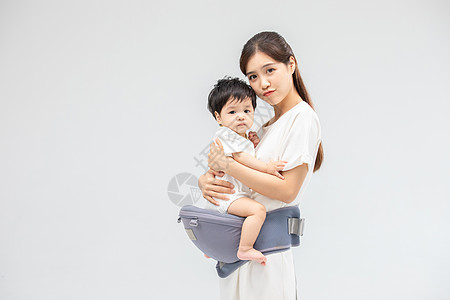 婴儿背带年轻妈妈使用宝宝腰凳带娃背景