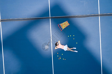 躺在网球场地上休息的女性图片
