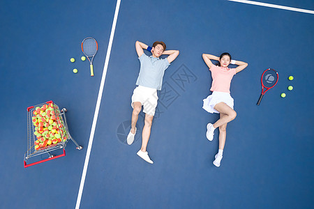 躺在网球场地上休息的青年情侣高清图片