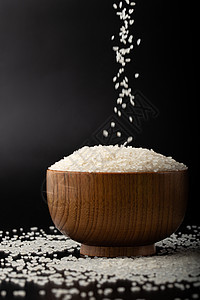 拍摄散落木碗里的大米背景图片