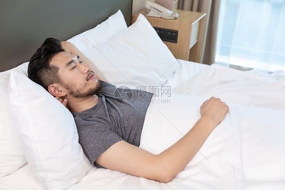 青年男性在酒店里睡觉休息图片