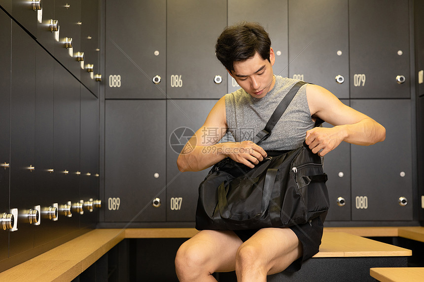 在休息室整理包的健身男性图片
