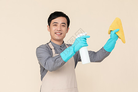 手持喷壶与抹布做清洁的家政服务男性背景图片