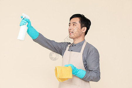 手持喷壶与抹布做清洁的家政服务男性图片