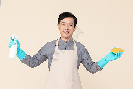 手持喷壶与海绵做清洁的家政服务男性背景图片