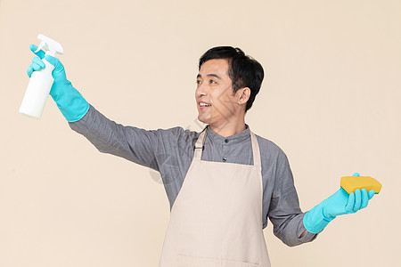 手持喷壶与海绵做清洁的家政服务男性图片