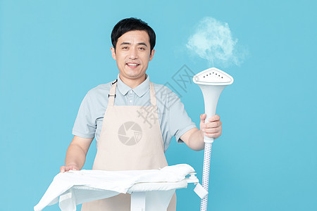 使用挂烫机熨烫衣服的家政服务男性图片