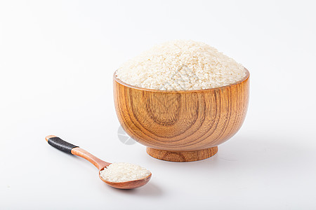 白色背景拍摄木碗里的大米图片