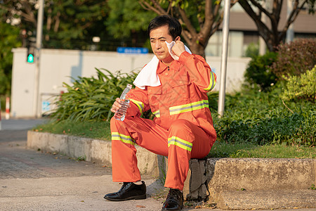 在马路旁喝水休息的环卫工人图片