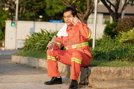 在马路旁喝水休息的环卫工人图片