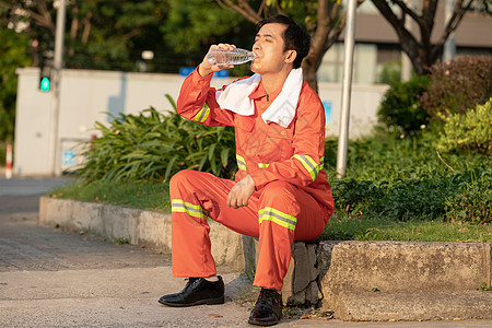 在马路旁喝水休息的环卫工人背景图片