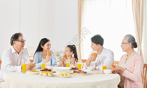 中秋团员家庭聚餐吃月饼背景图片