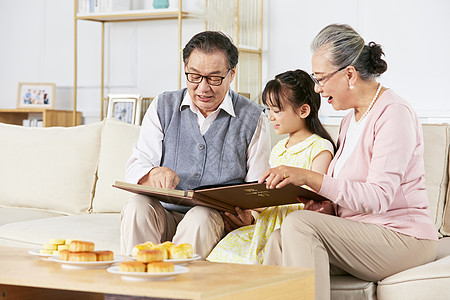 小女孩中秋节和爷爷奶奶翻看相册高清图片