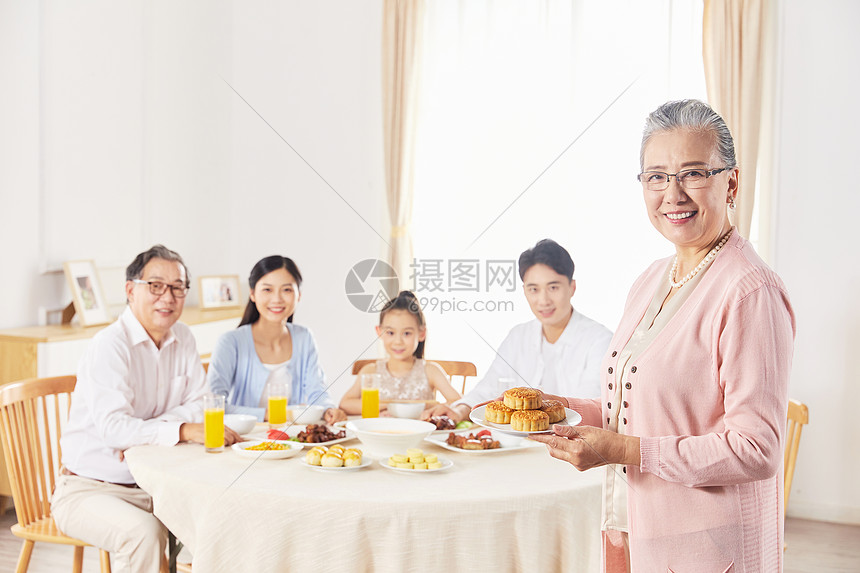 奶奶端着月饼给一家人吃图片