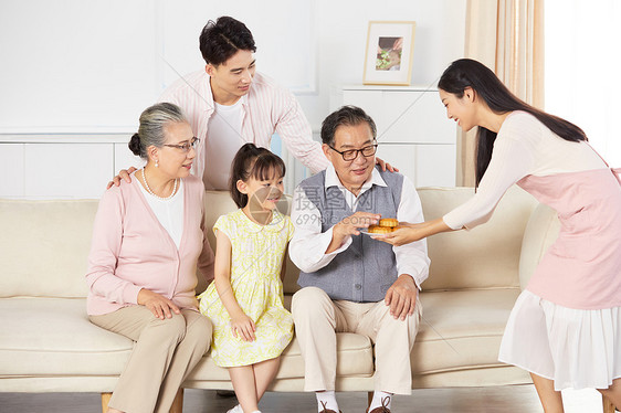 年轻妈妈的端着月饼给家人吃图片