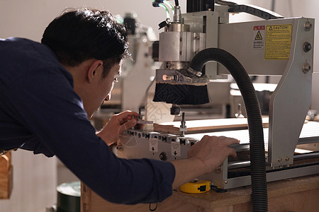 中国手艺男性木工匠操作数控设备背景