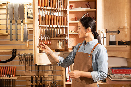 木匠美女工人检查手工工具图片