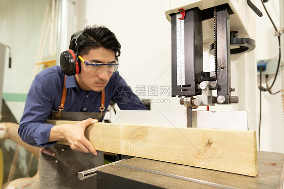 木匠男性工人锯木头图片