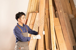 男性木工挑选木材物料图片