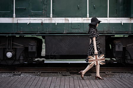 火车站月台提着行李箱的女人背景图片