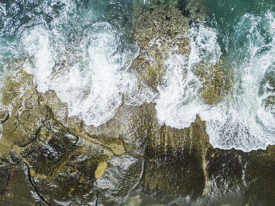 海浪撞击礁石翻腾出漂亮的浪花图片