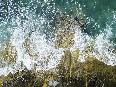 海浪撞击礁石翻腾出漂亮的浪花背景图片