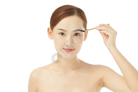 使用睫毛刷刷眉毛的女性图片