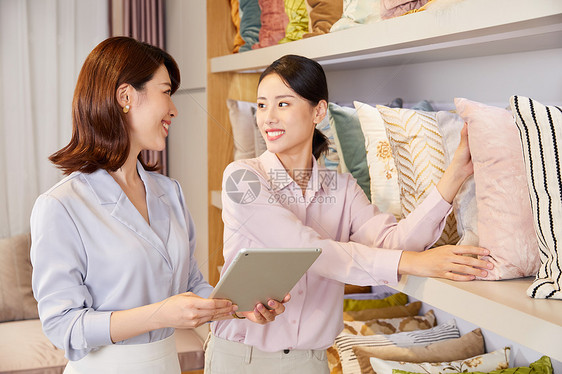 年轻女性软装店选购抱枕图片