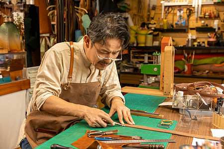男性工匠手工制作皮带背景图片