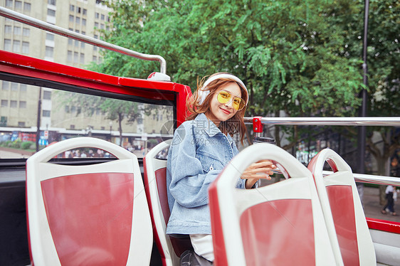 坐观光大巴旅游伸手欢呼的年轻女孩图片