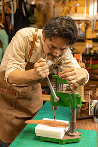 男性皮匠切割真皮鞋垫图片