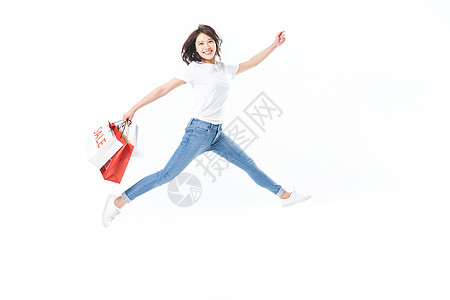 年轻美女手拿购物袋跳跃动作图片