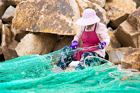 织渔网的渔民图片