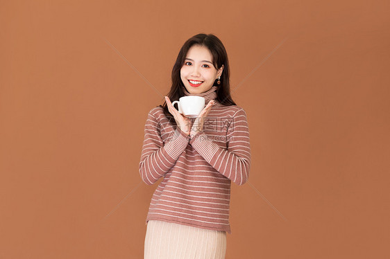 秋季文艺女性手捧咖啡杯图片