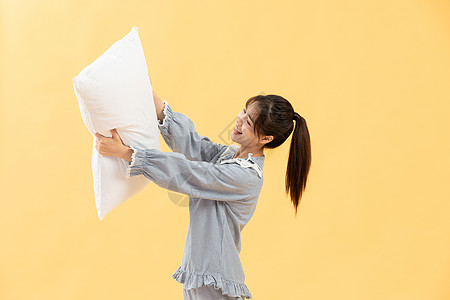 穿着睡衣的女孩手抱枕头图片