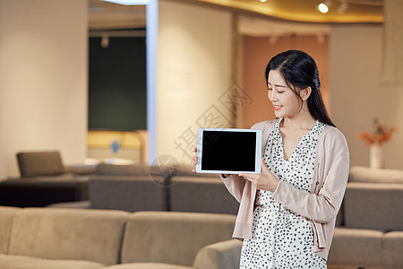 年轻美女手拿平板电脑展示背景图片