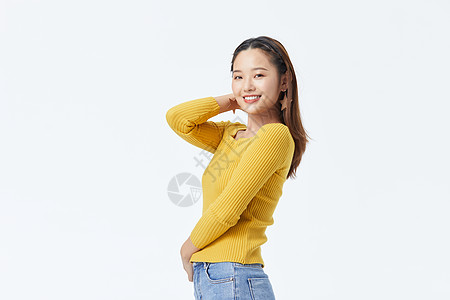 穿黄色毛衣单手撩头发的长发美女图片