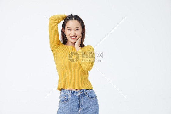 穿黄色毛衣单手摸头发的长发美女图片