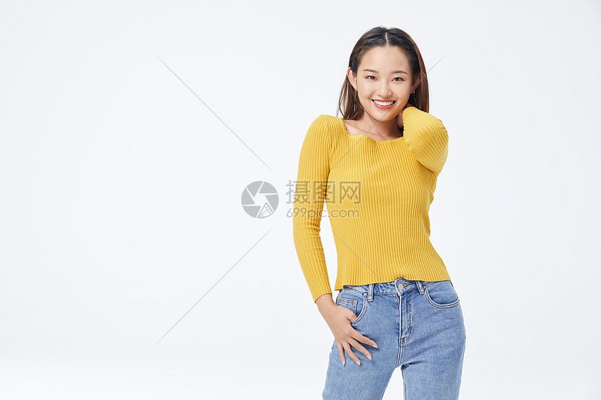 穿黄色毛衣单手插口袋的长发美女图片