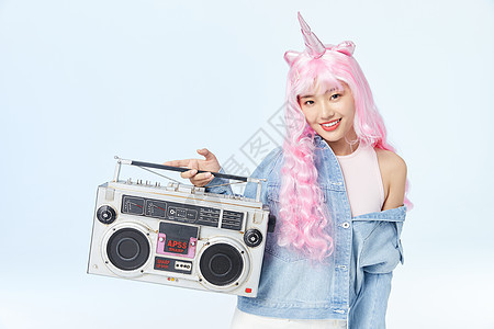 单手提着录音机的时尚粉色长发美女图片