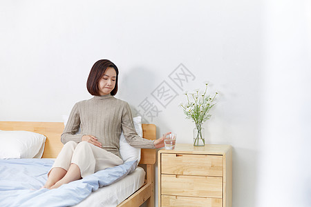 高龄产妇坐在床上喝水图片
