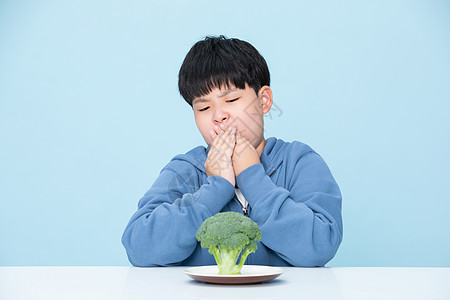 不喜欢吃花菜的小男孩捂着嘴图片