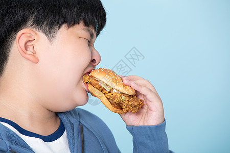 小男孩大口吃汉堡肥胖的男孩背景图片